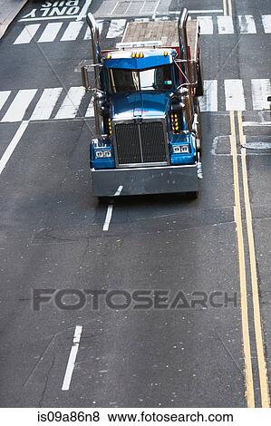 Stock Photo - Blue truck driving on city street. Fotosearch