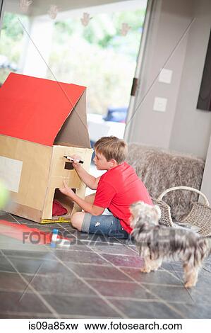 Stock Photo - Boy building kennel for his dog. Fotosearch