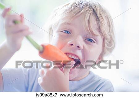 Stock Photo - Boy eating carrot. Fotosearch