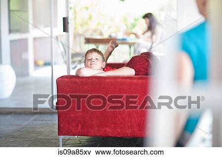 Stock Photo - Boy lying on sofa. Fotosearch