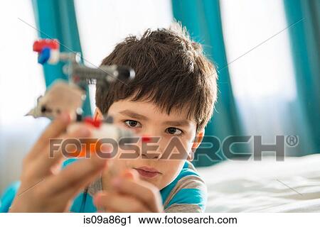 Boy playing with toy in bedroom View Large Photo Image Stock Image - Boy playing with toy in bedroom. Fotosearch