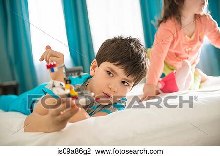 Boy playing with toy in bedroom View Large Photo Image Stock Image - Boy playing with toy in bedroom. Fotosearch