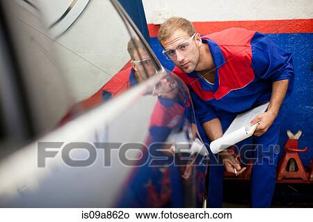 Car mechanic at work in service bay View Large Photo Image Picture - Car mechanic at work in service bay. Fotosearch