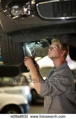 Stock Image - Car mechanic at work in service bay. Fotosearch