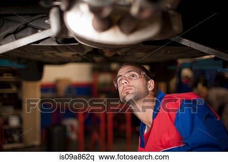 Car mechanic at work in service bay View Large Photo Image Stock Photography - Car mechanic at work in service bay. Fotosearch