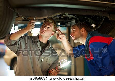 Car mechanics discussing and analyzing car repair View Large Photo Image Stock Image - Car mechanics discussing and analyzing car repair. Fotosearch