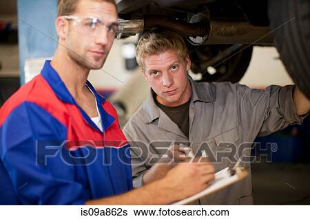 Car mechanics discussing and analyzing car repair View Large Photo Image Stock Photograph - Car mechanics discussing and analyzing car repair. Fotosearch