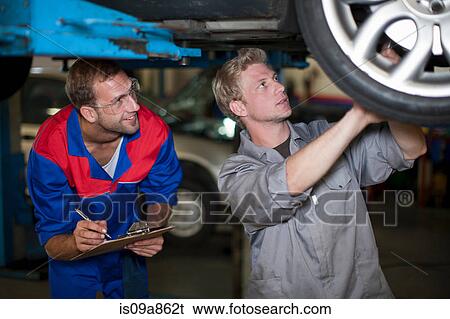 Car mechanics discussing and analyzing car repair View Large Photo Image Stock Photograph - Car mechanics discussing and analyzing car repair. Fotosearch