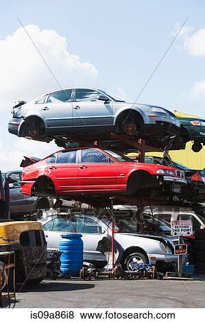 Stock Photo - Cars stacked in scrap yard. Fotosearch