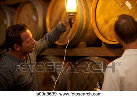 Checking wine aging in barrels View Large Photo Image Stock Photo - Checking wine aging in barrels. Fotosearch