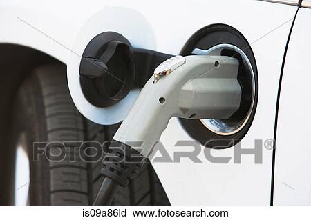 Stock Image - Close up of gasoline nozzle filling car tank. Fotosearch