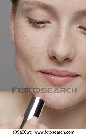 Close up of part of young woman's face, applying lipstick View Large Photo Image Stock Image - Close up of part of young woman's face, applying lipstick. Fotosearch