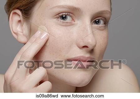 Close up of part of young woman's face, applying concealer View Large Photo Image Stock Image - Close up of part of young woman's face, applying concealer. Fotosearch