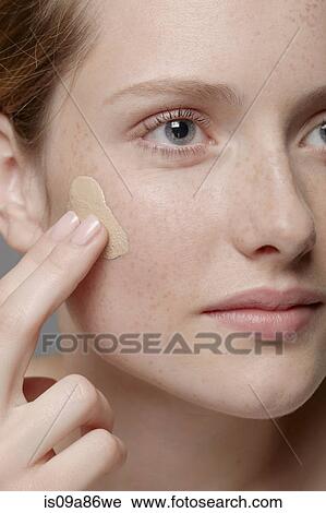 Close up of part of young woman's face, applying concealer View Large Photo Image Stock Image - Close up of part of young woman's face, applying concealer. Fotosearch