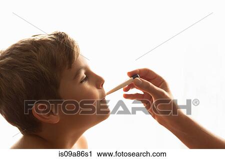 Stock Image - Cropped shot of mother's hand taking son's temperature. Fotosearch