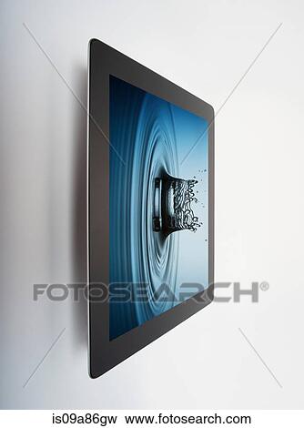 Digital tablet with crown shaped water drop splash on screen View Large Photo Image Stock Photo - Digital tablet with crown shaped water drop splash on screen. Fotosearch