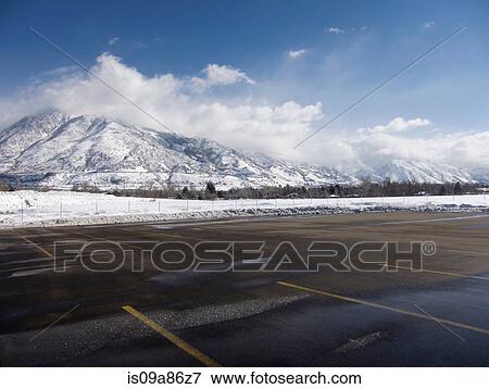 Stock Photo - Empty parking lot with snow covered Wasatch Mountains in background, Salt Lake City, Utah, USA. Fotosearch