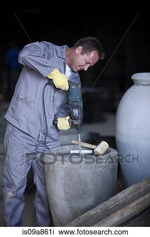 Factory worker drilling into large vase View Large Photo Image Stock Image - Factory worker drilling into large vase. Fotosearch