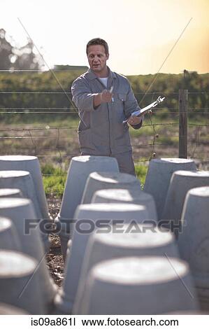 Factory worker pointing at large vases View Large Photo Image Stock Image - Factory worker pointing at large vases. Fotosearch