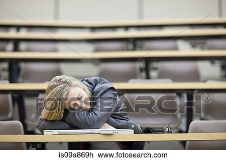 Stock Image - Female student asleep in lecture. Fotosearch