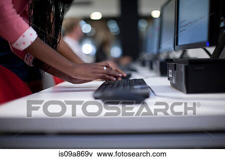 Stock Photo - Female student using computer keyboard in class. Fotosearch
