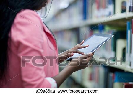 Female student using digital tablet in library View Large Photo Image Stock Image - Female student using digital tablet in library. Fotosearch