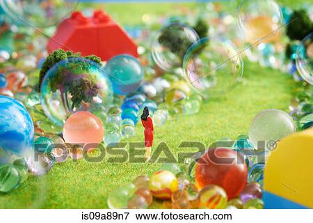 Stock Photo - Figurines on pretend grass with marbles. Fotosearch