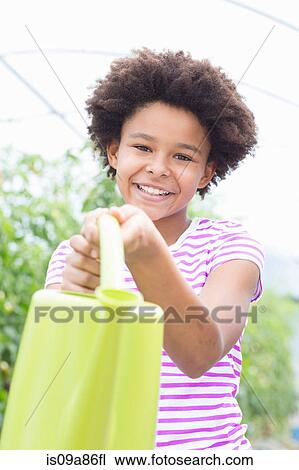Girl holding green watering can View Large Photo Image Stock Image - Girl holding green watering can. Fotosearch