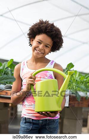 Stock Photo - Girl holding green watering can. Fotosearch
