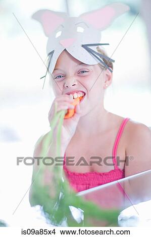 Girl in rabbit costume eating carrot View Large Photo Image Picture - Girl in rabbit costume eating carrot. Fotosearch