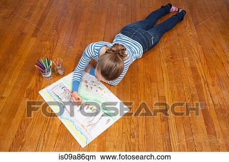 Picture - Girl lying on floor drawing picture. Fotosearch