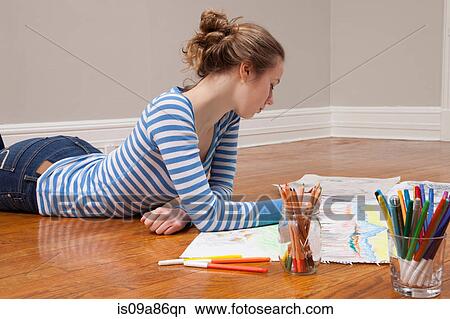 Girl lying on floor drawing picture View Large Photo Image Picture - Girl lying on floor drawing picture. Fotosearch