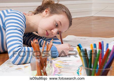Girl lying on floor drawing picture View Large Photo Image Picture - Girl lying on floor drawing picture. Fotosearch