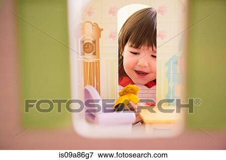 Stock Photo - Girl playing with doll house. Fotosearch