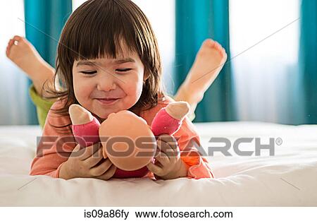 Girl playing with dolly in bedroom View Large Photo Image Stock Photo - Girl playing with dolly in bedroom. Fotosearch