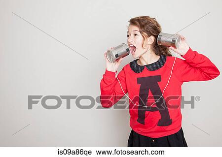 Girl shouting into tin can telephone View Large Photo Image Stock Image - Girl shouting into tin can telephone. Fotosearch