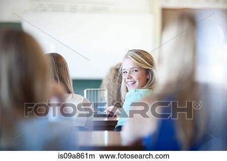 Girl turning around to look at her classmates View Large Photo Image Picture - Girl turning around to look at her classmates. Fotosearch
