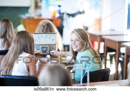 Girl turning around to look at her classmates View Large Photo Image Picture - Girl turning around to look at her classmates. Fotosearch