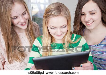 Girls looking at digital tablet View Large Photo Image Stock Image - Girls looking at digital tablet. Fotosearch