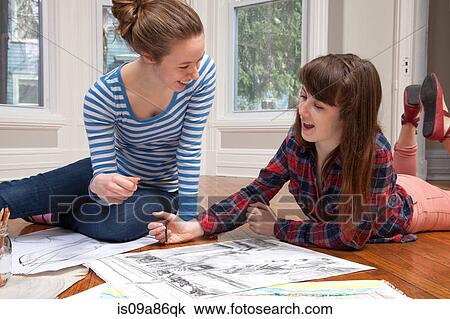 Girls lying on floor drawing pictures View Large Photo Image Stock Image - Girls lying on floor drawing pictures. Fotosearch