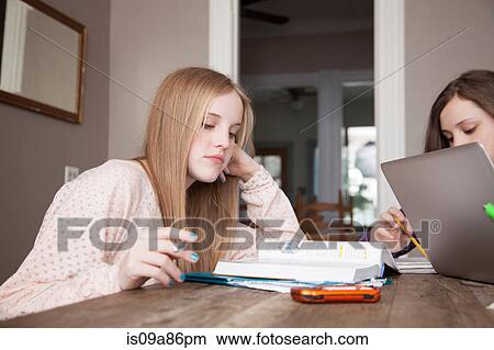 Girls sitting at table studying View Large Photo Image Picture - Girls sitting at table studying. Fotosearch