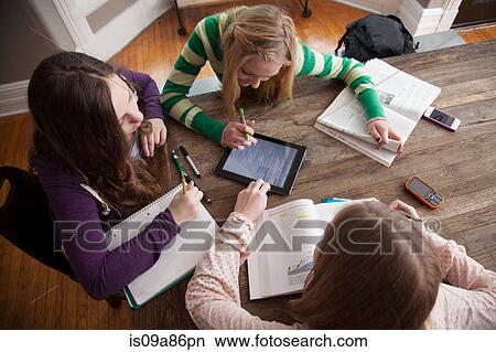 Picture - Girls sitting at table studying. Fotosearch
