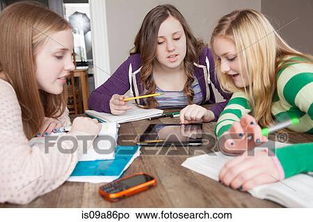 Girls sitting at table studying View Large Photo Image Picture - Girls sitting at table studying. Fotosearch