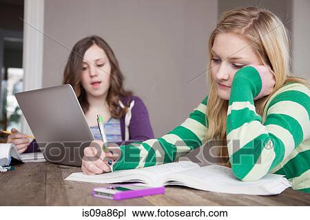 Stock Image - Girls sitting at table studying. Fotosearch