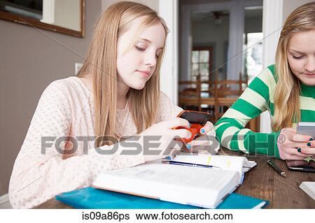 Stock Photograph - Girls sitting at table studying. Fotosearch