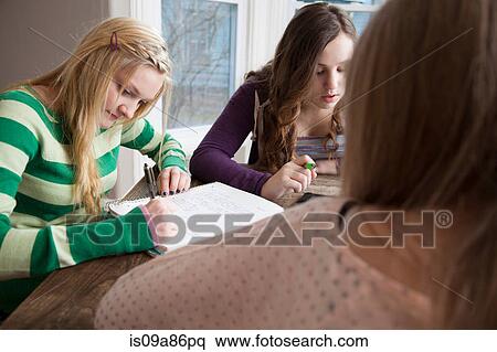 Girls sitting at table studying View Large Photo Image Stock Photography - Girls sitting at table studying. Fotosearch