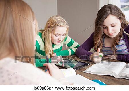 Stock Photography - Girls sitting at table studying. Fotosearch