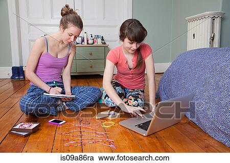Girls sitting on bedroom floor with laptop, making friendship bracelets View Large Photo Image Stock Image - Girls sitting on bedroom floor with laptop, making friendship bracelets. Fotosearch