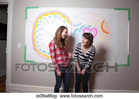 Stock Photo - Girls standing in front of mural laughing. Fotosearch