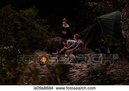 Picture - Group of young people in front of campfire. Fotosearch